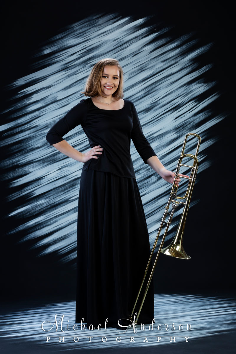 A fun, formal senior photo created of a Centennial High School Marching Band member holding her trombone.