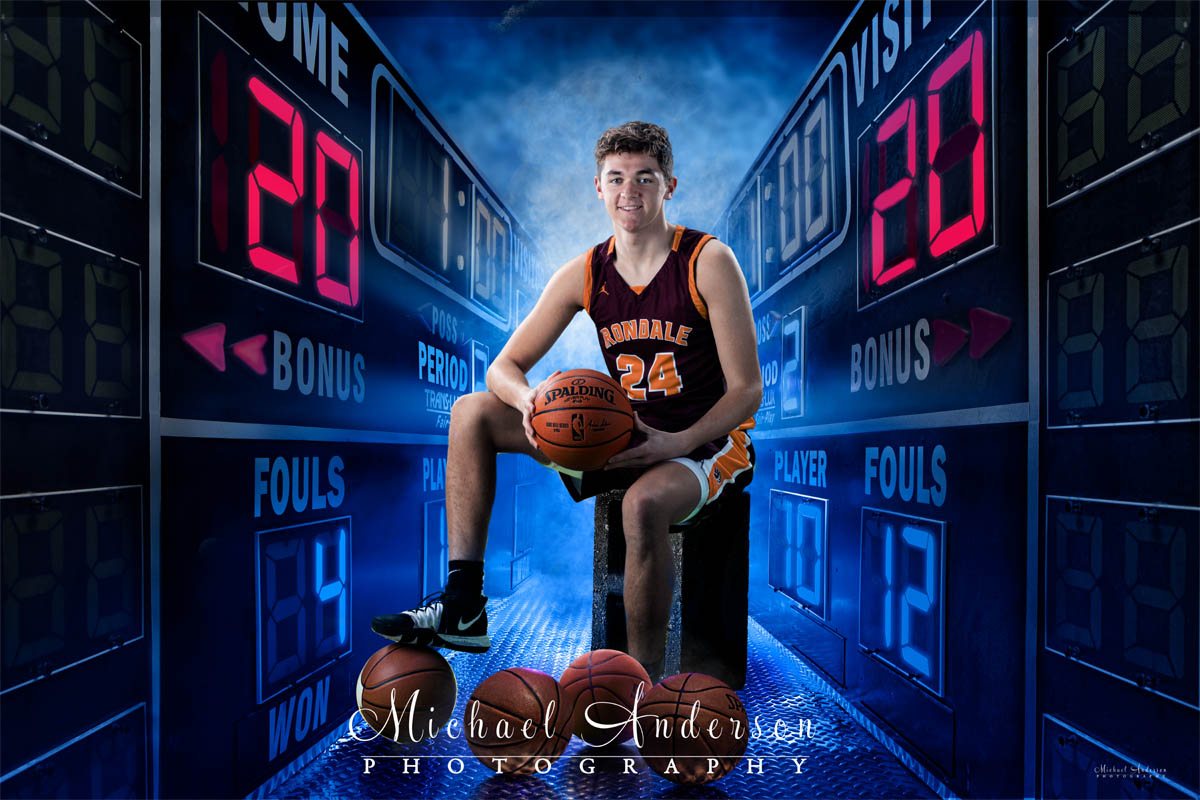 The Class of 2020 Irondale High School boys basketball composite. Player sitting in between two scoreboards.