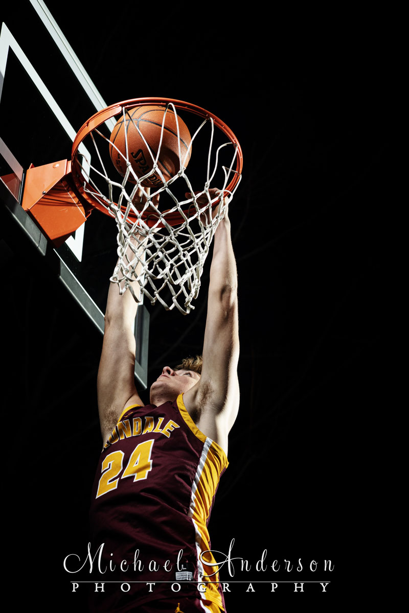 Close up of an Irondale High School senior boy dunking a basketball.