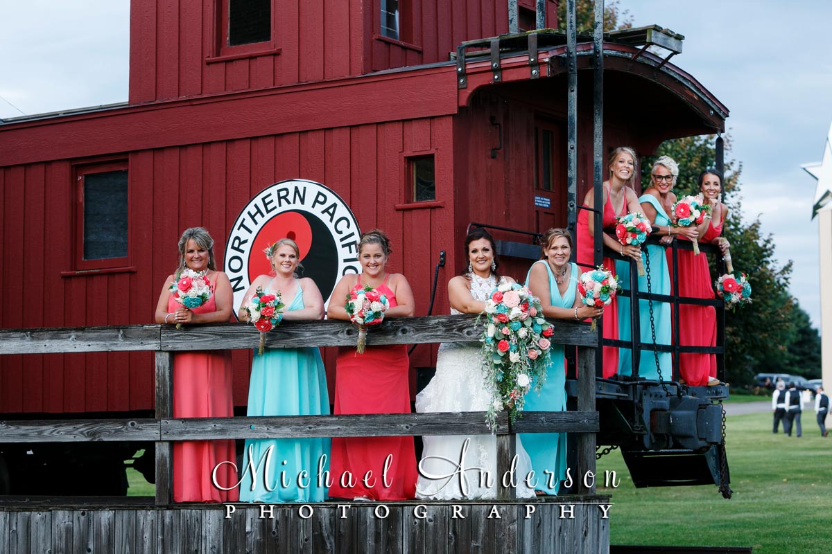 The bride and her bridesmaids on a caboose on display at Little Log House Pioneer Village.