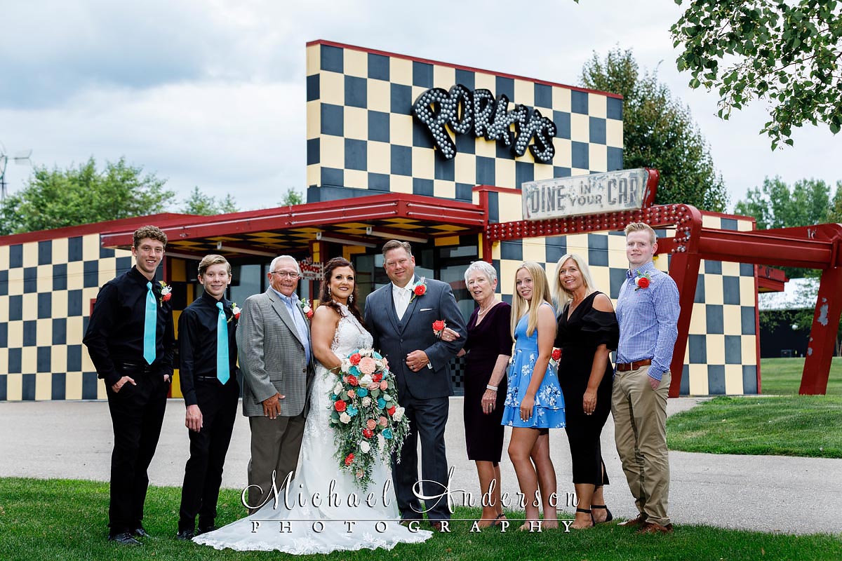 The groom's extended family photo at "Porkys Drive-In" at Little Log House Pioneer Village.