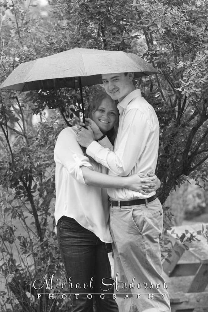 A cute couple under an umbrella.