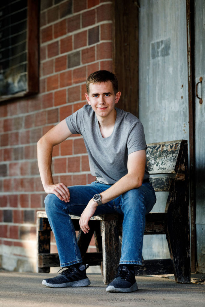 A nice senior photo of a boy at a feed store.