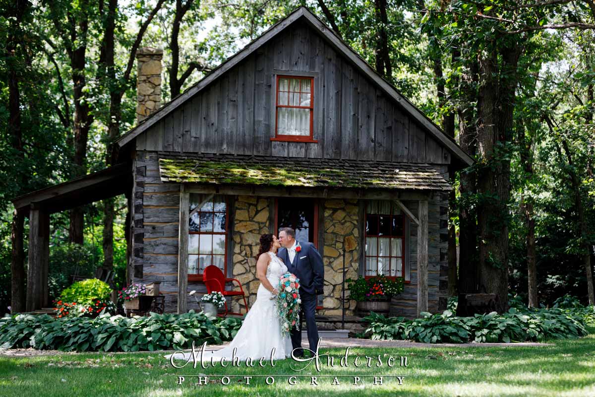 A nice wedding photo of the bride and groom outside The Little Log House.