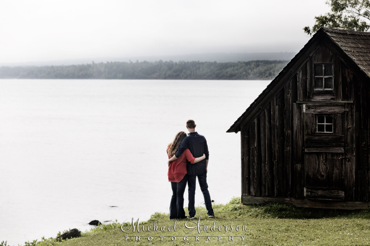 North Shore engagement portrait by an old wooden boathouse on Lake Superior.