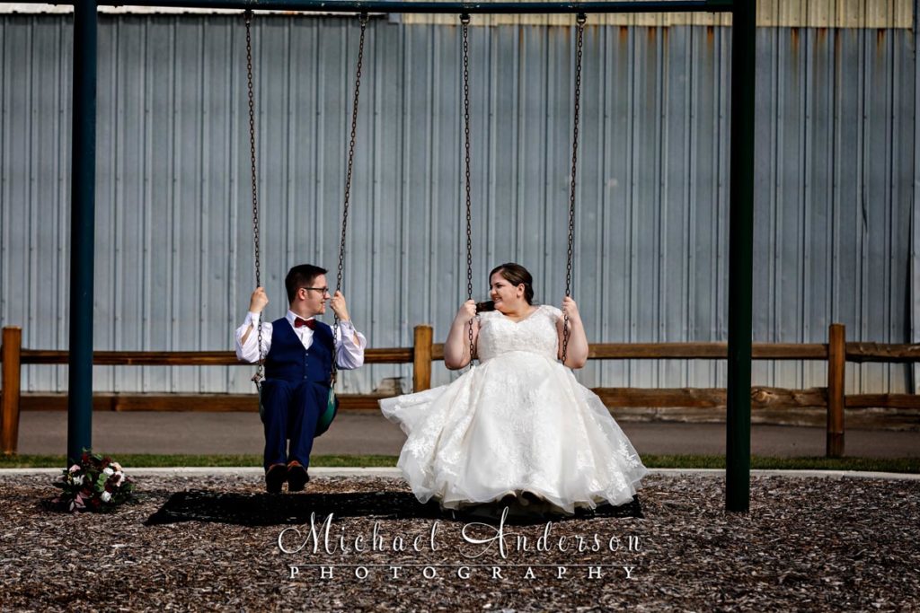 A fun wedding picture of a bride and groom on a swing set in Lake Elmo, MN.