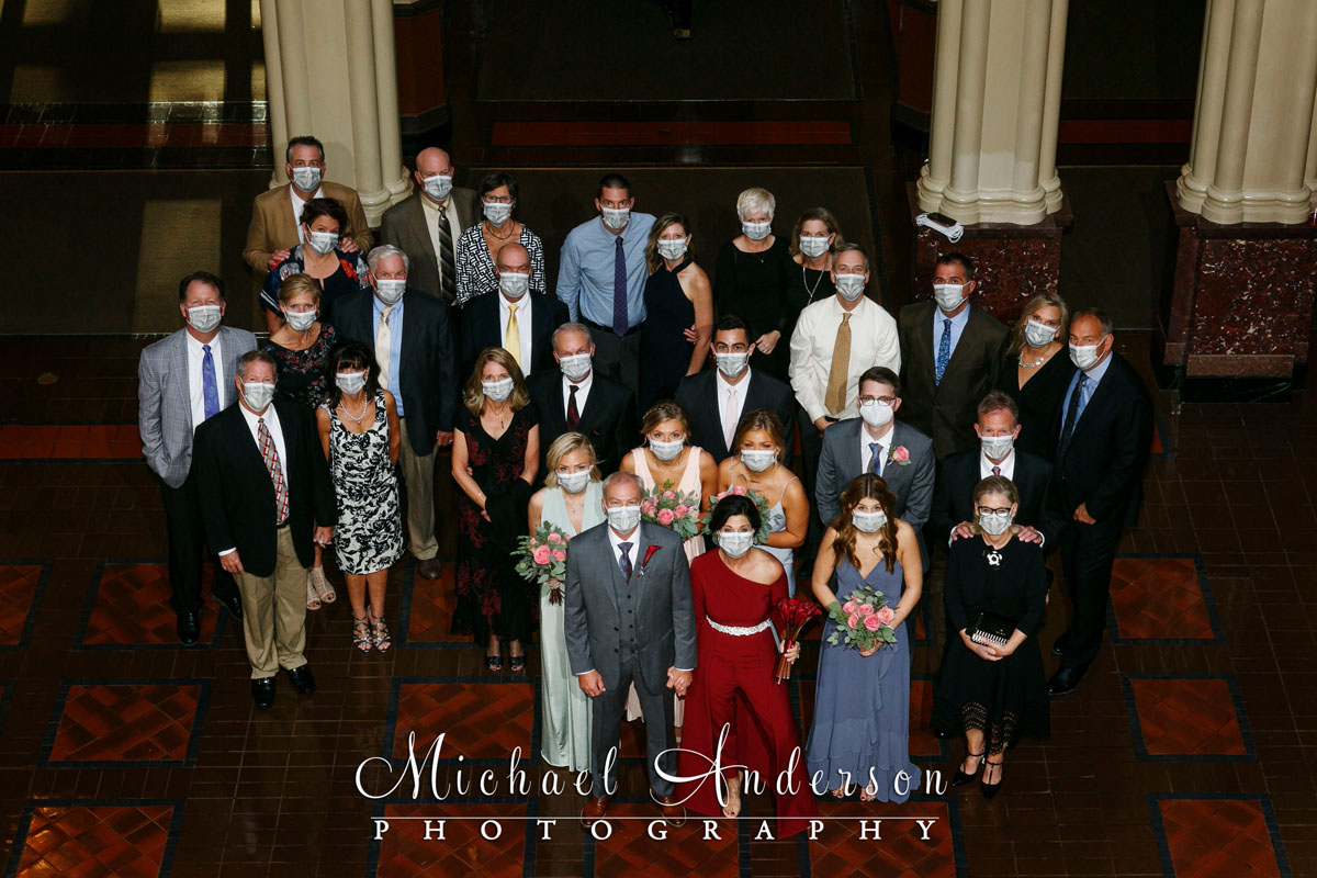 Landmark Center wedding ceremony photo of the bride, groom, and all of their wedding guests wearing masks.