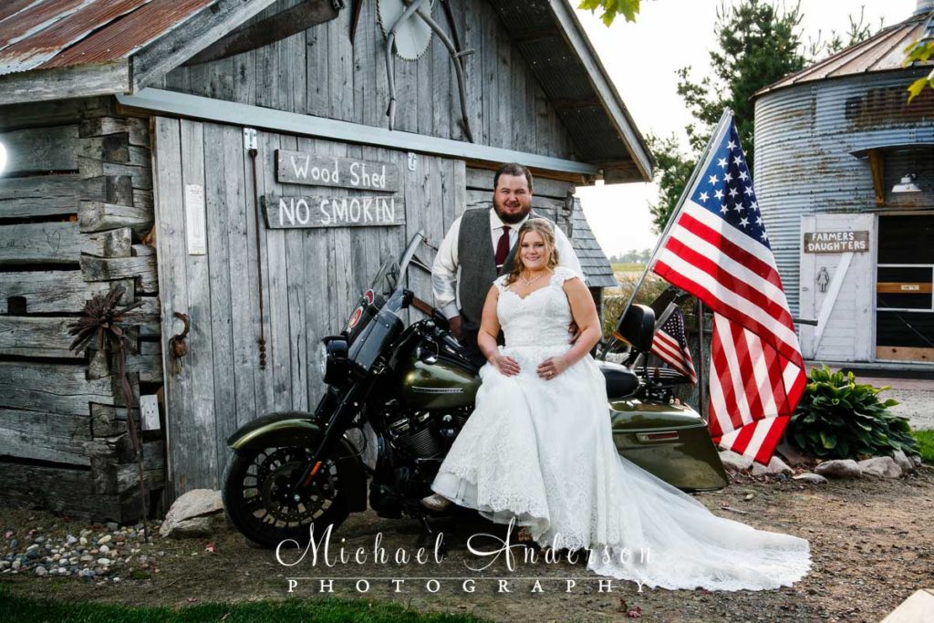 Deglman Farm wedding reception photo of the bride & groom sitting on a Harley Davidson motorcycle.