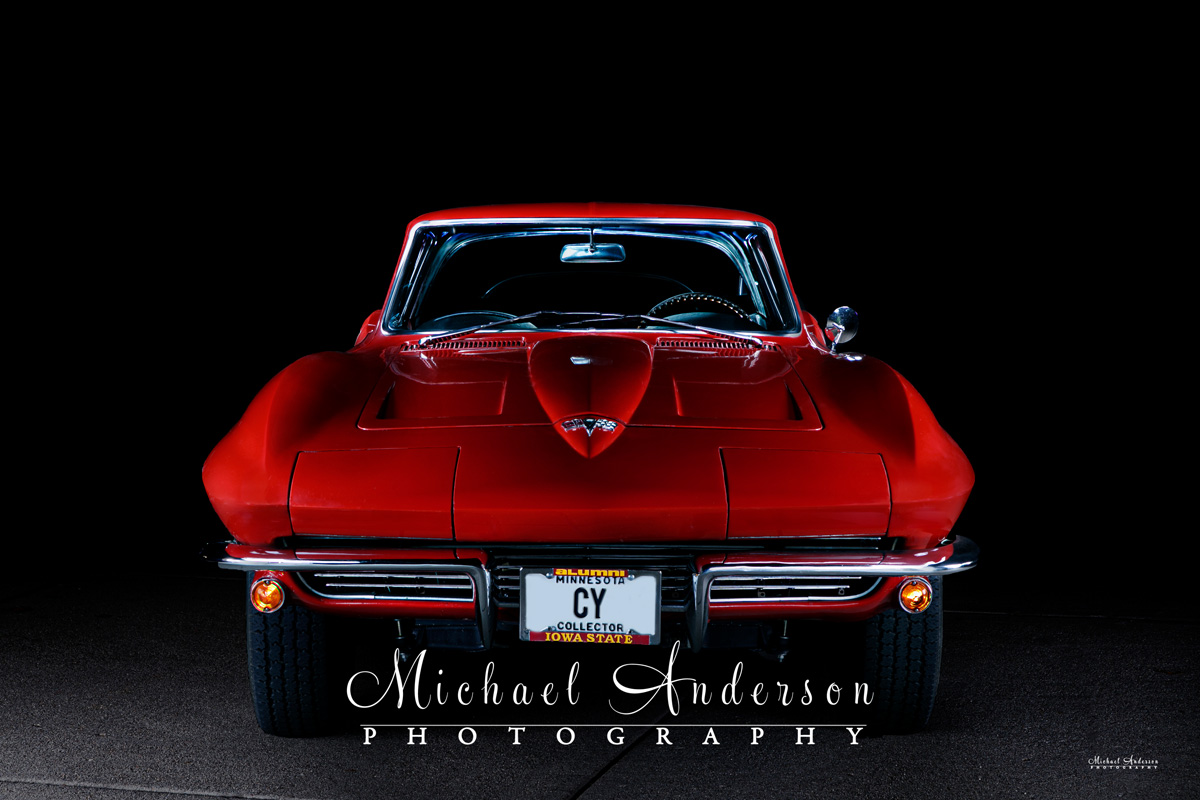 A sleek light painted photograph of the front end of a 1964 Corvette.