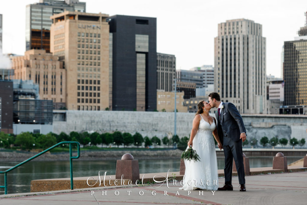 Pretty wedding photograph of the bride and groom kissing at sunset on Harriet Island.