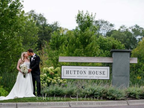 Bride and groom kissing at the entrance to The Hutton House in Medicine Lake, MN.