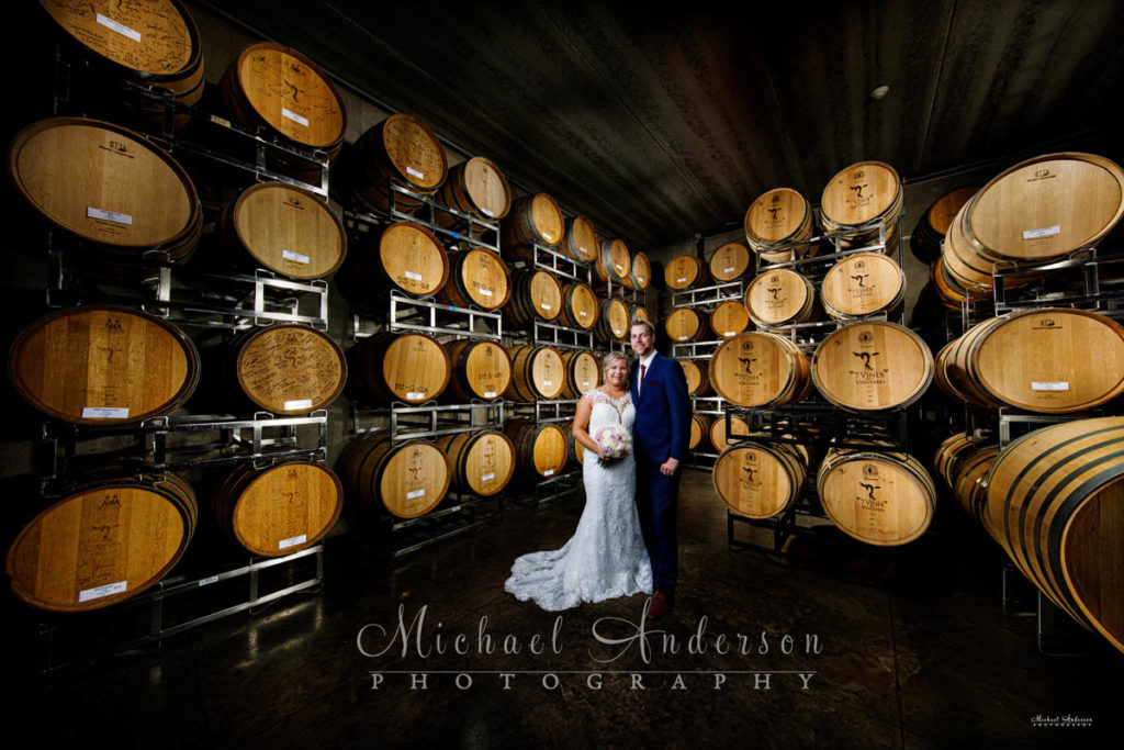 A cool light painted wedding photograph of the bride and groom in the Barrel Room at 7 Vines Vineyard.