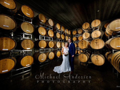 A cool light painted wedding photograph of the bride and groom in the Barrel Room at 7 Vines Vineyard.