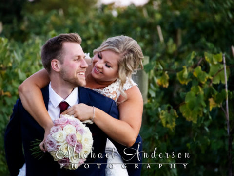 The bride and groom having fun out in the vineyard during their 7 Vines Vineyard wedding reception.