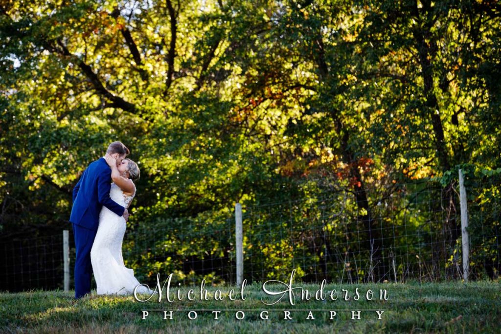 The bride and groom kissing near the vineyard during their 7 Vines Vineyard wedding reception.