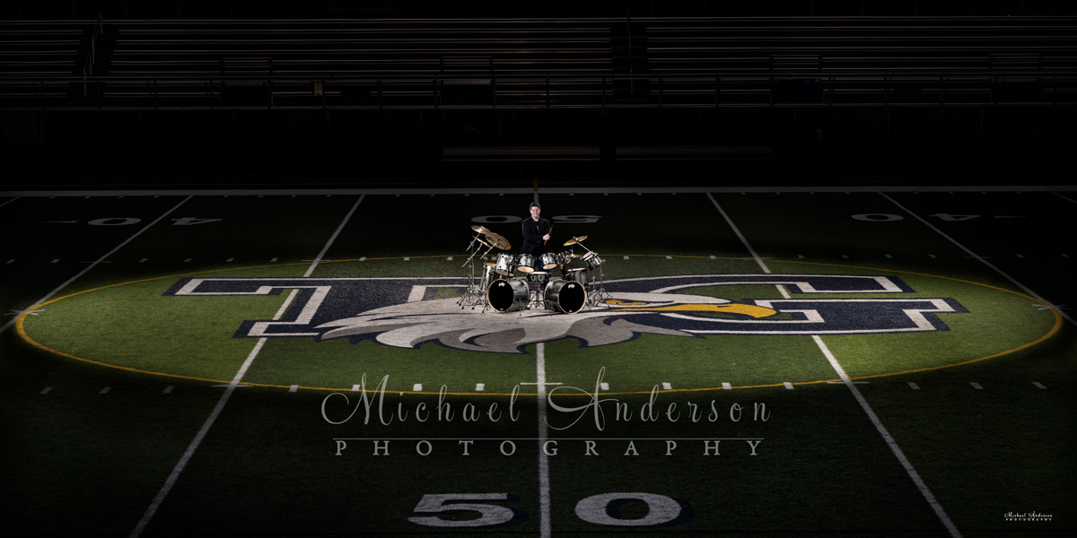 A really cool light painted senior photo of a boy, with his drums, on the 50-yard line at Totino Grace High School in Fridley, MN.