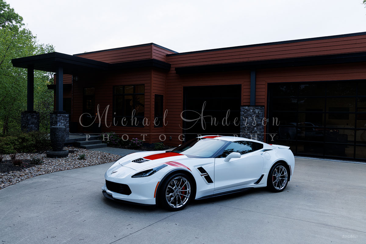 Photograph of a 2017 Corvette Grand Sport in front a beautiful contemporary home in the Ozarks.