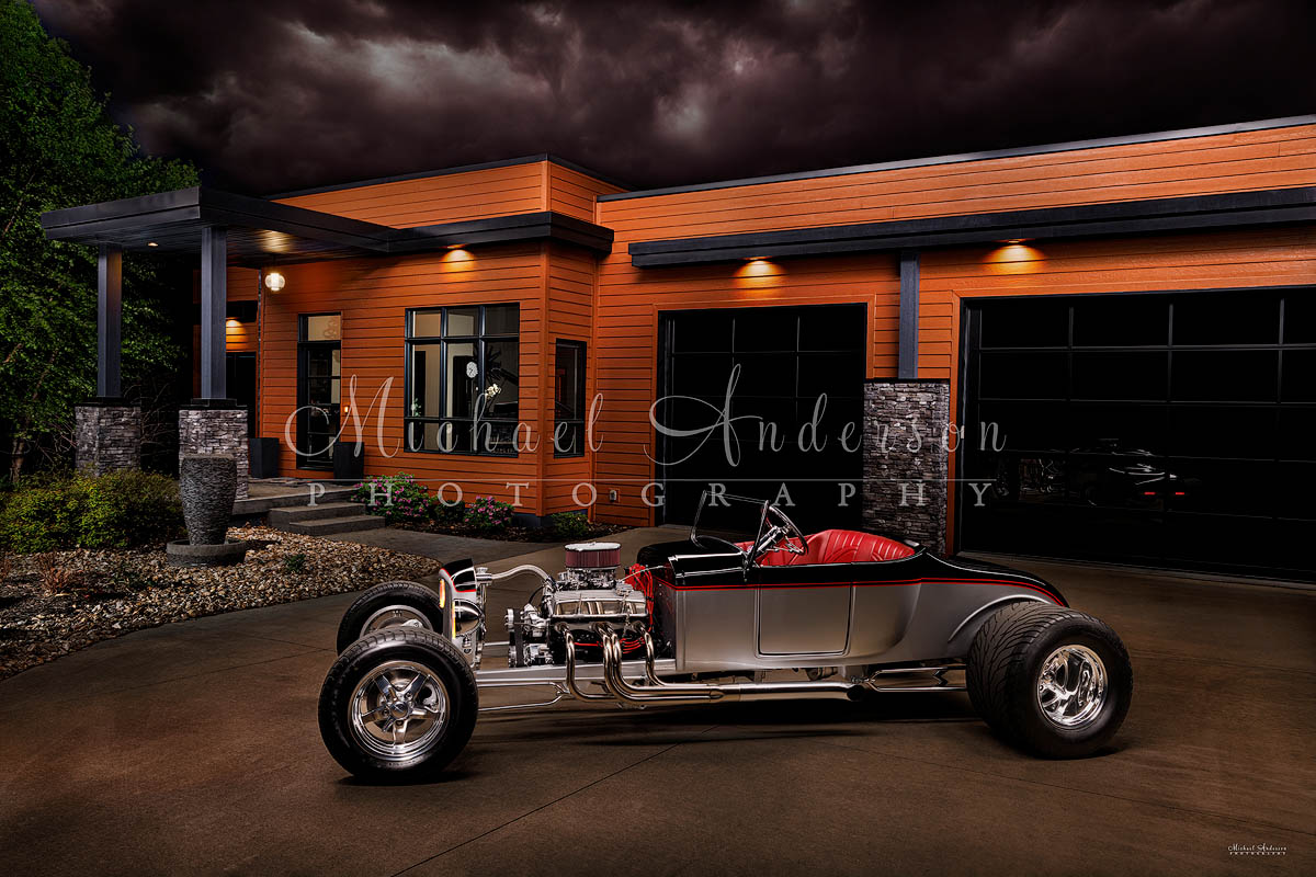 A stunning light painted photo of a 1927 Spirit T Roadster in front of a beautiful contemporary home.