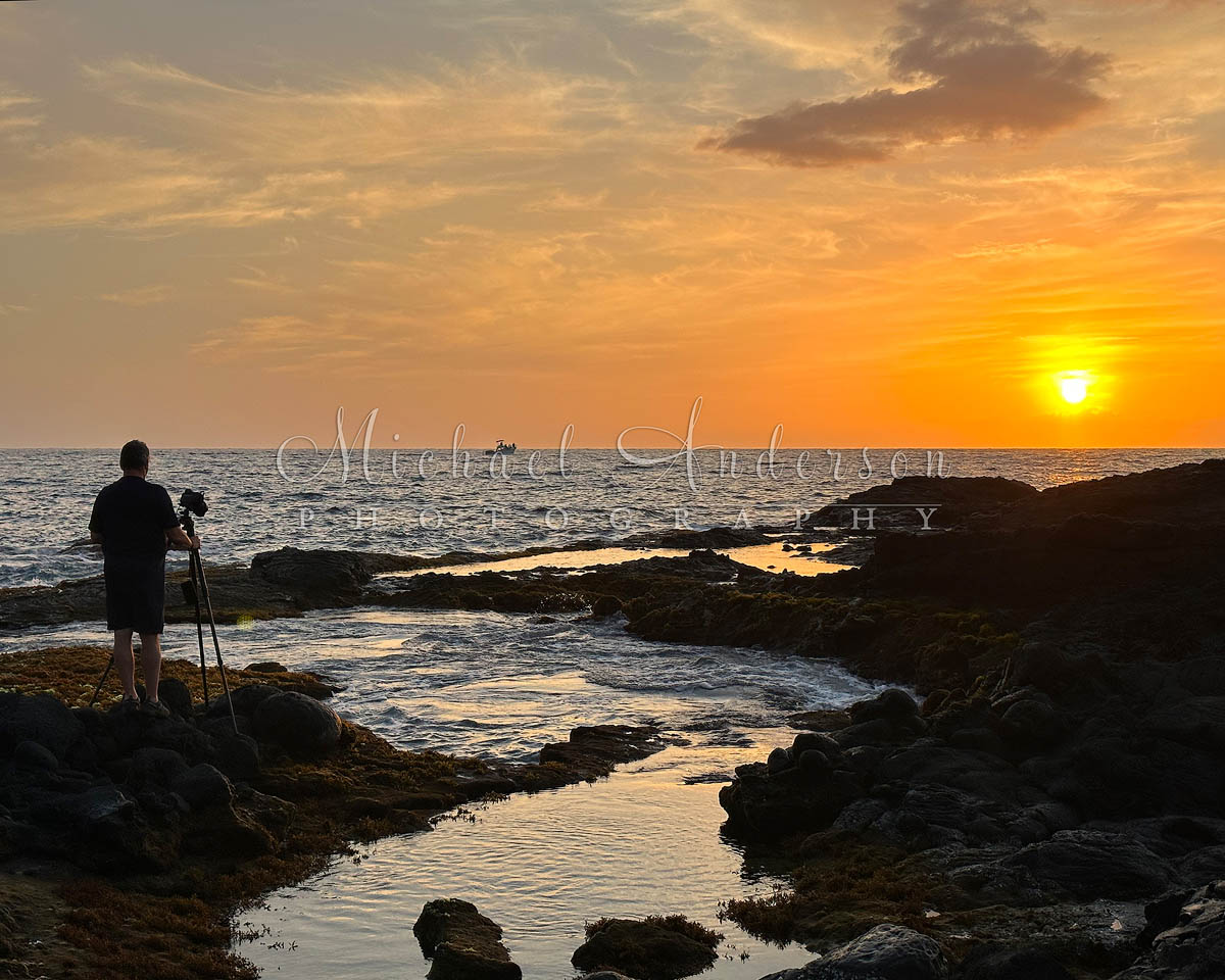 A photographer capturing a pretty sunset at Pele's Well near Kona on the Big Island of Hawaii.