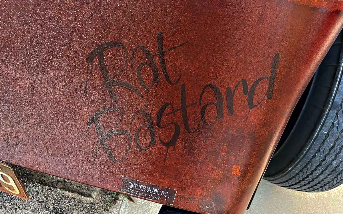 A custom hand painted name "Rat Bastard" on the fender of a 1933 Chevy 2-Door Sedan.
