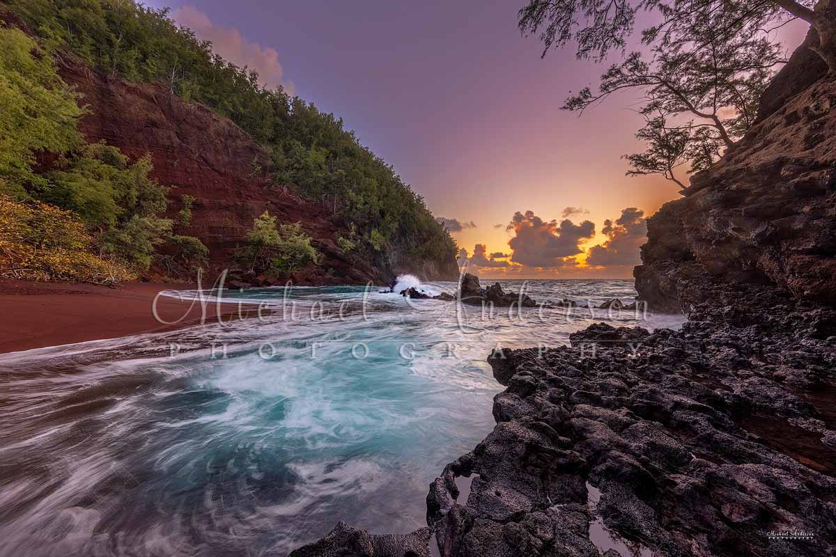 An incredible sunrise at Kaihalulu Red Sand Beach in Hana, on the island of Maui, Hawaii.