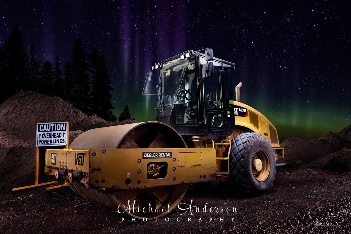 A cool light painting of a Caterpillar CS56B Vibratory Soil Compactor under the Aurora Borealis!