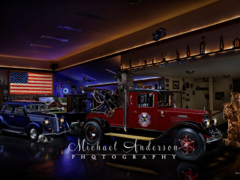 A wonderful light painted photograph of a 1927 International Wrecker and a 1936 Ford Sedan in a Man Cave.