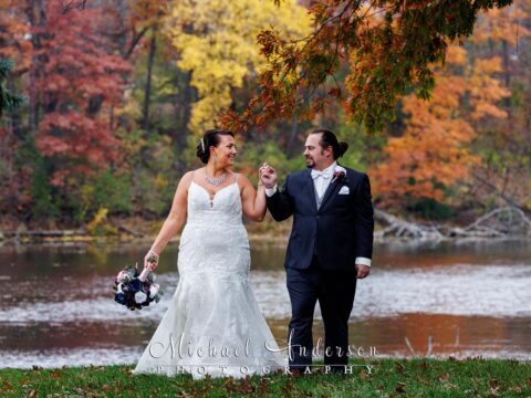 A pretty wedding photo of the bride and groom walking near the lake at the Chart House in Lakeville, Minnesota.