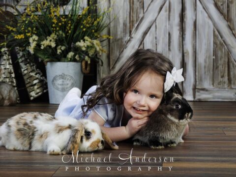 An adorable three-year-old cuddling a real Easter bunny.
