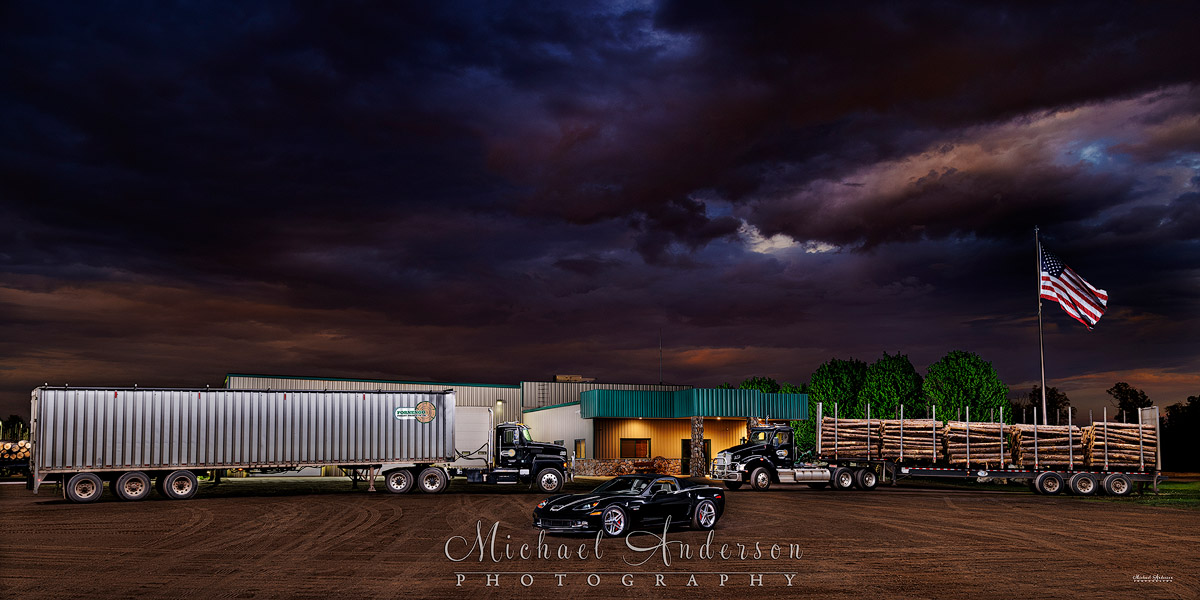 A cool light painted photograph of a Kenworth T880, a Mack P164T, and a 2006 Corvette Z06 at the headquarters of Fornengo Forest Products in Danbury, WI.
