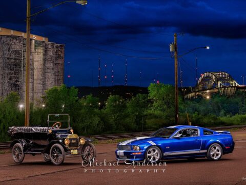 A pretty light painted photograph of a 1915 Ford Model T and a 2008 Ford Shelby Mustang near the shipping docks in Superior, Wisconsin.