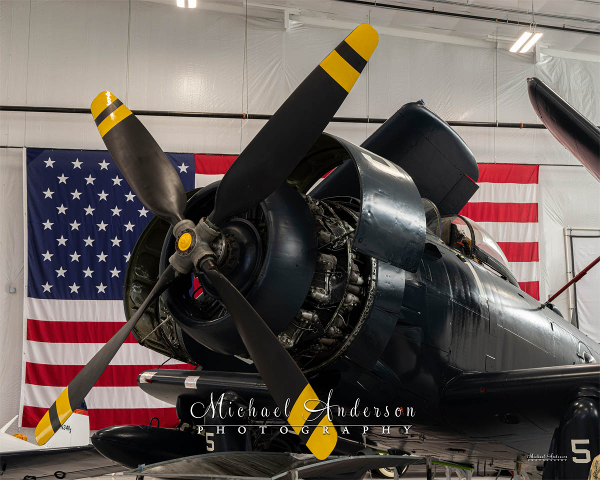 Photo of a 1952 AD-4N Skyraider with the American Flag behind it. This was the starting image taken just prior to light painting the aircraft.