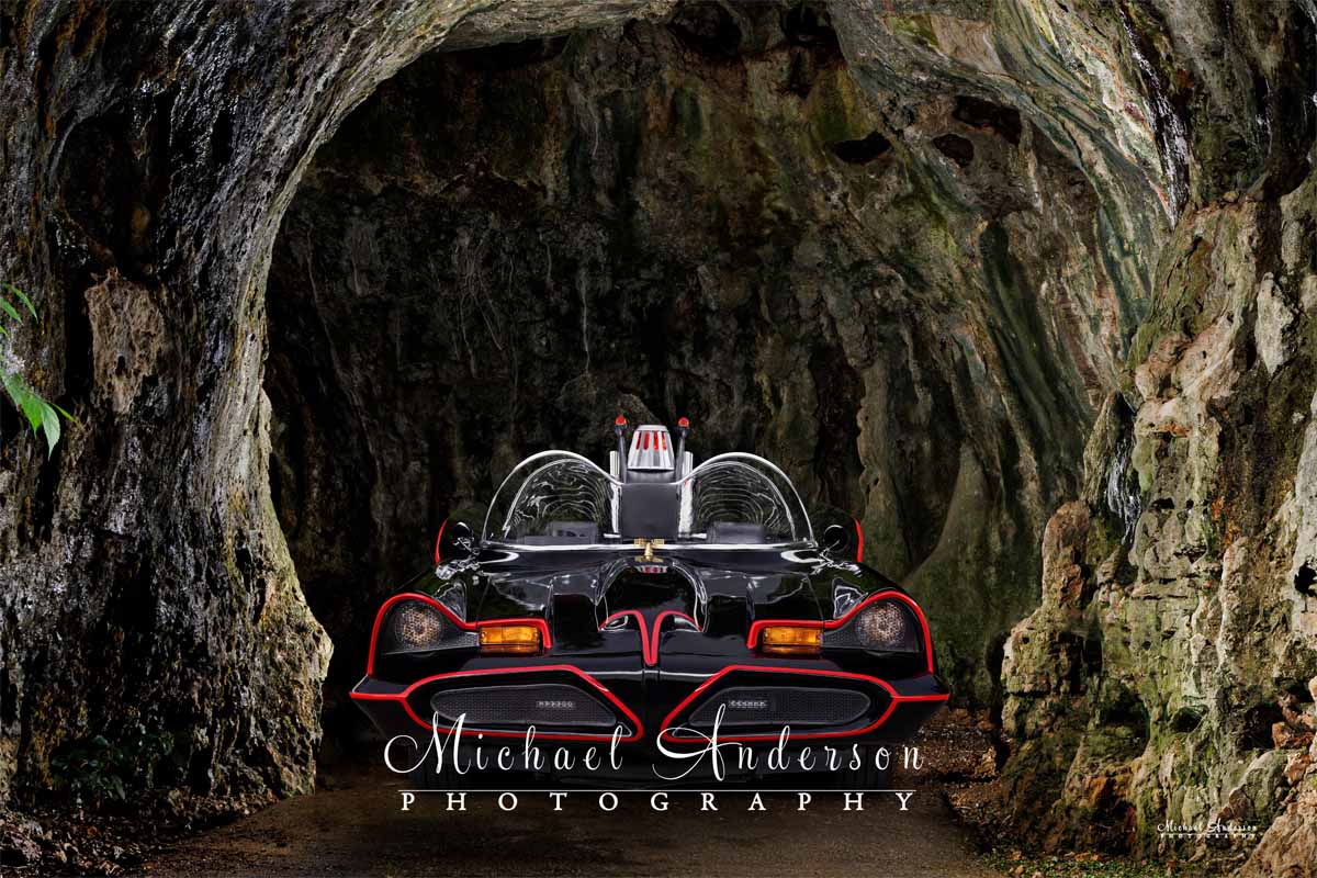 Cool light painted photograph of the Batmobile in the entrance to the Batcave.