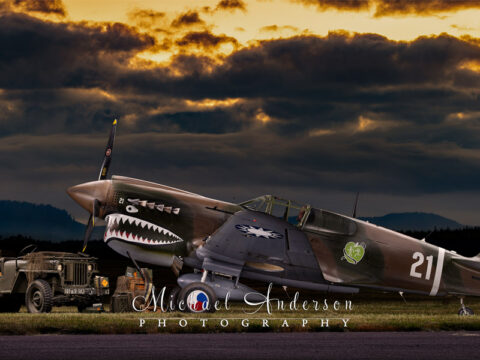 A stunning light painted photograph of a restored P-40 N-1 Kittyhawk and a WWII Willys Jeep.