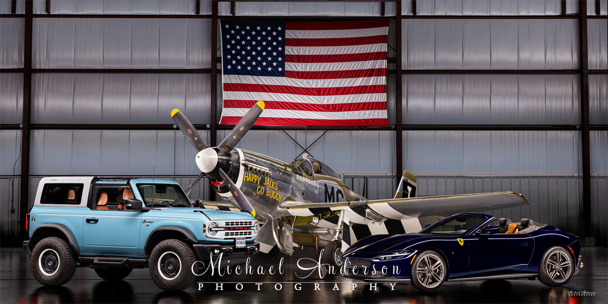 A wonderful light-painted photograph of three very unique vehicles. From left to right is a 2024 Ford Bronco Heritage Edition, the famous P-51 D Mustang “Happy Jack's Go Buggy”, and a 2025 Ferrari Roma Spider!
