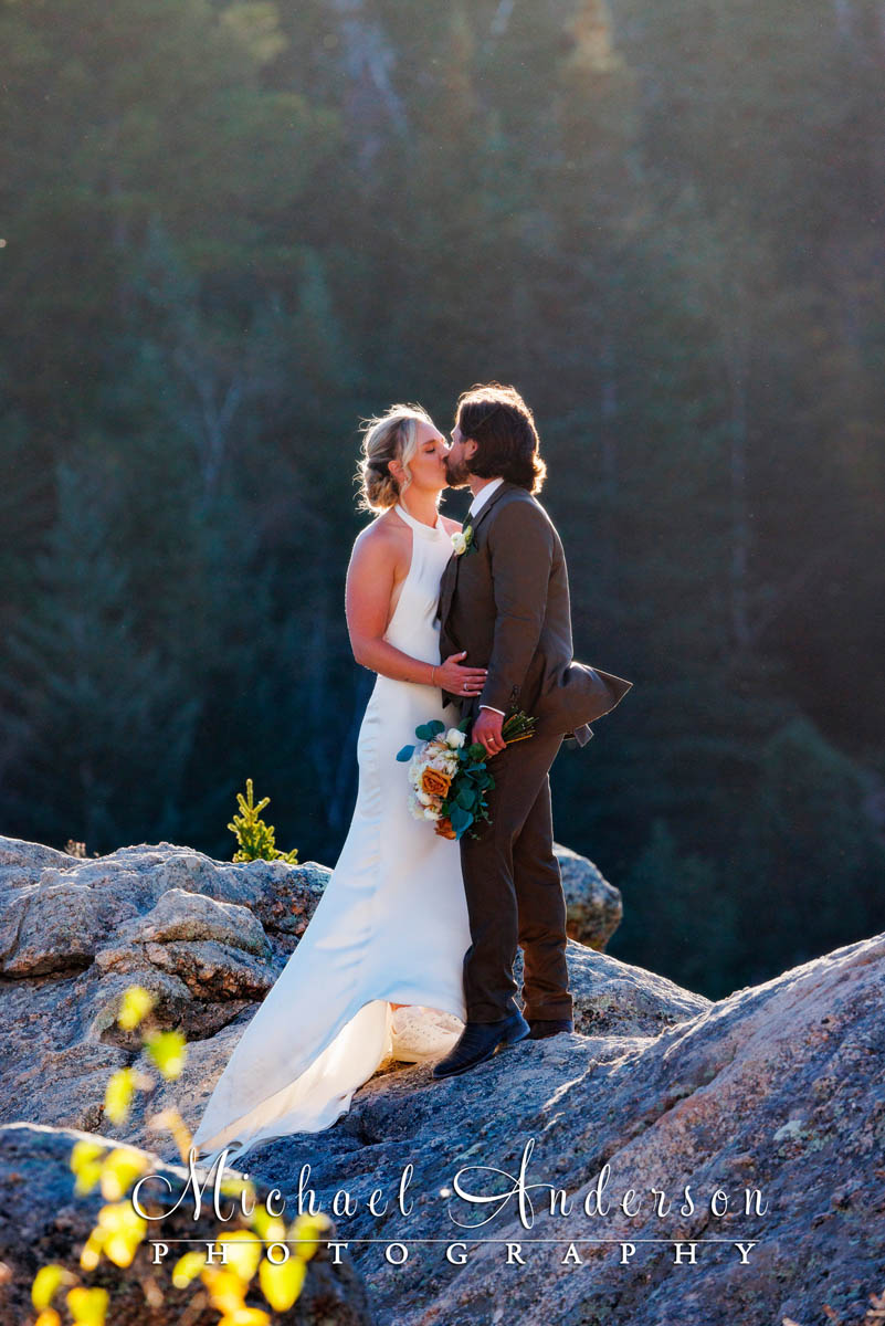 A pretty wedding photo of a couple kissing on the granite rock formations at Sylvan Lake in Custer State Park.